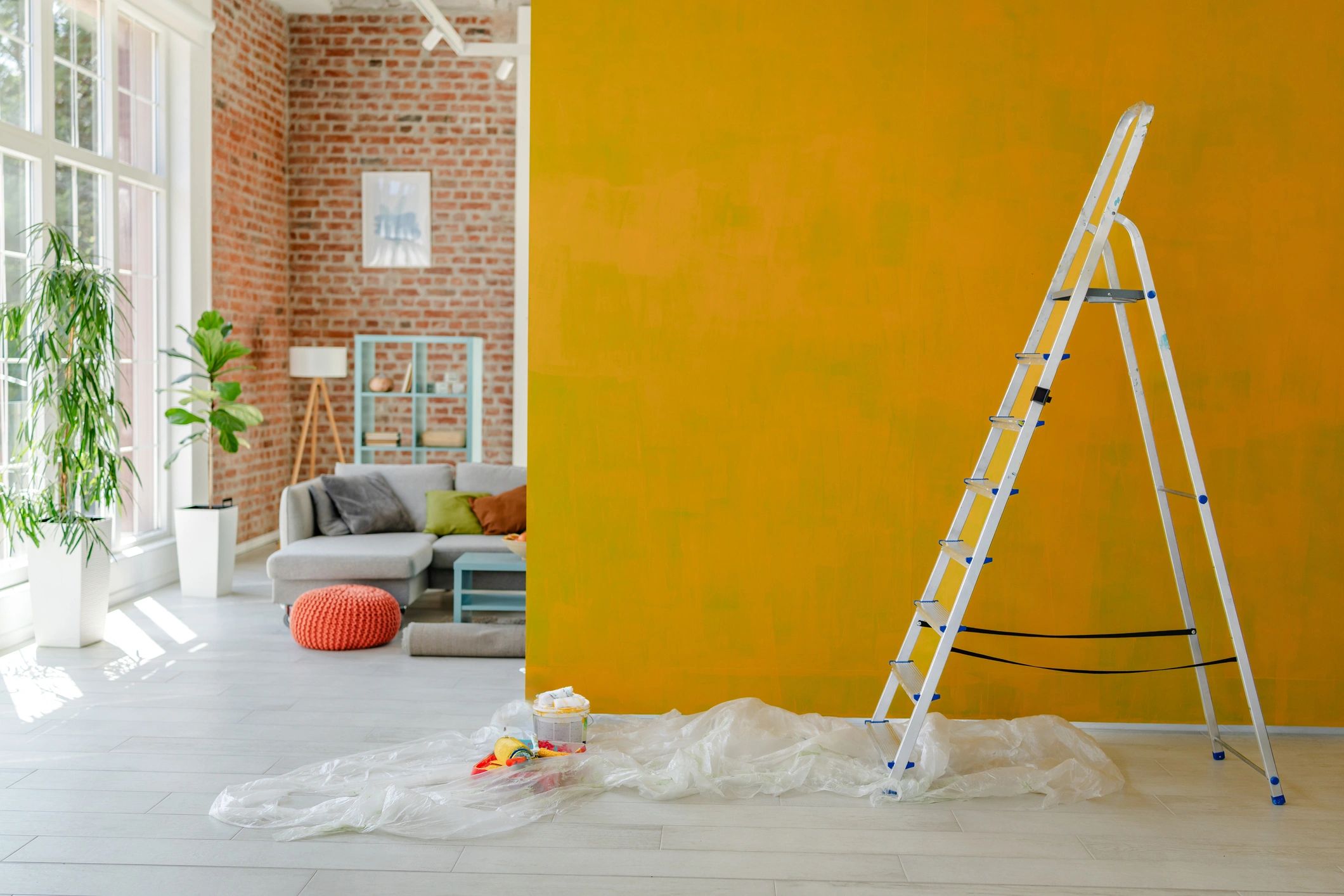 Interior home improvement workspace with ladder beside a wall